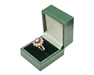 Lot 115 - An impressive diamond and oval ruby cluster ring, set in heavy yellow gold.