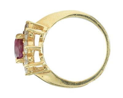 Lot 115 - An impressive diamond and oval ruby cluster ring, set in heavy yellow gold.