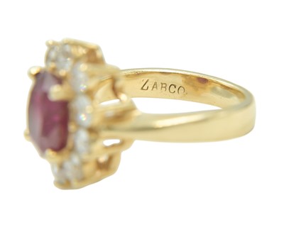 Lot 115 - An impressive diamond and oval ruby cluster ring, set in heavy yellow gold.