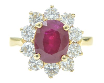 Lot 115 - An impressive diamond and oval ruby cluster ring, set in heavy yellow gold.