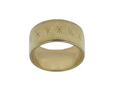 Lot 92 - A 9k wide band ring with star cut decoration.