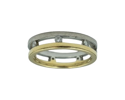 Lot 94 - A modern 18k bi-colour metal band ring, torsion set with seven round brilliant cut diamonds.