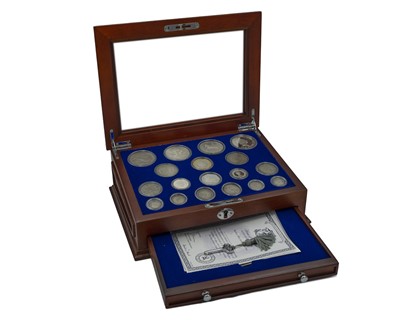 Lot 7 - The House of Windsor Silver Coin Collection by Danbury Mint, in deluxe wooden collector's cabinet.