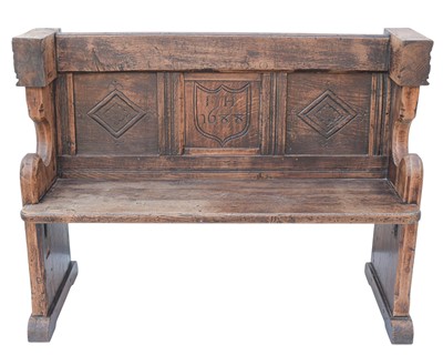 Lot 855 - A carved oak pew/settle.
