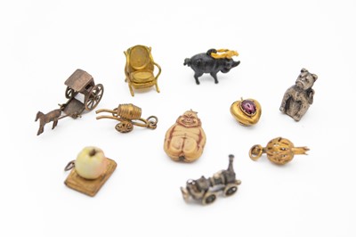 Lot 237 - A selection of charms, including a yellow metal and garnet cabochon set charm, with locket panel.