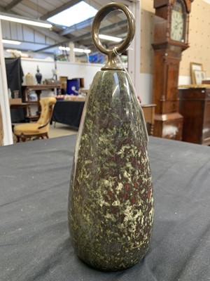 Lot 18 - A Cornish red serpentine doorstop with brass loop handle.