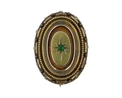 Lot 173 - A Victorian gold oval mourning brooch, star set with a green garnet.