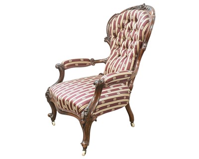 Lot 932 - A Victorian carved walnut button back armchair.