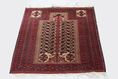 Lot 448 - A Belouch prayer rug, the camel mihrab with...