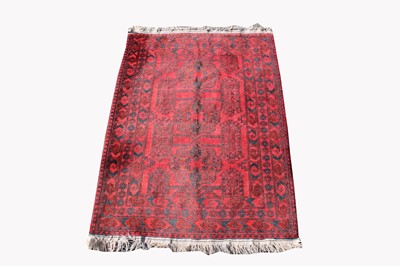 Lot 499A - An Afghan rug, the madder field with three...