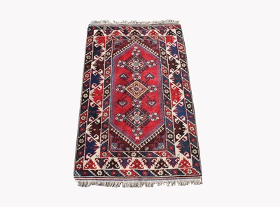 Lot 499D - A Turkish rug, the madder field with three...