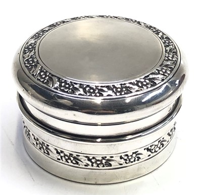 Lot 2088 - A lidded round silver box with two bands of...
