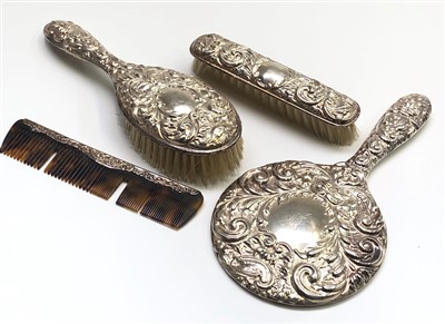 Lot 2116 - A four piece silver dressing set with embossed...