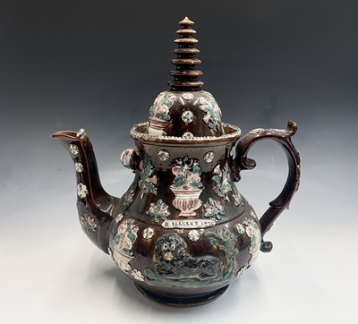 Lot 828 - A Measham treacle glazed barge ware teapot,...