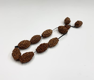 Lot 89 - A Chinese carved coquilla nut necklace
