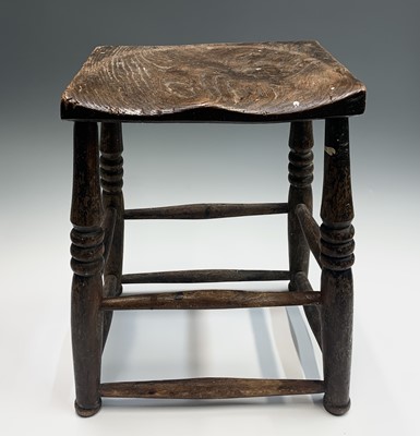 Lot 71 - An elm stool, 19th century, the dished seat on...