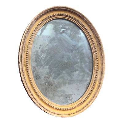 Lot 3344 - A small giltwood oval mirror, with original...