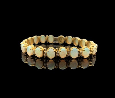 Lot 10 - An 18 ct gold bracelet with twenty opals, each...