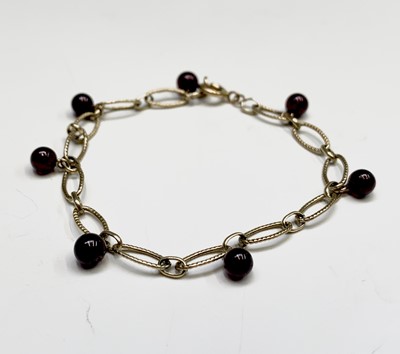 Lot 38 - A 9ct gold bracelet with seven garnet beads 4.7gm