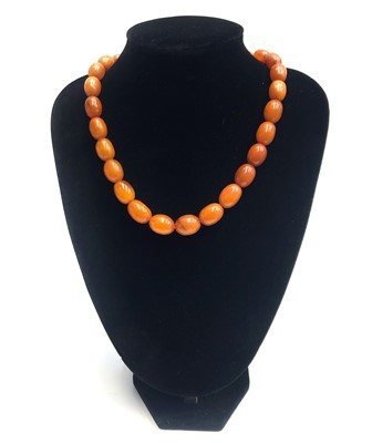 Lot 2470 - An amber necklace, the largest bead 17.8mm, 39....