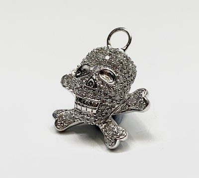 Lot 57 - An 18ct white gold skull and cross-bones...