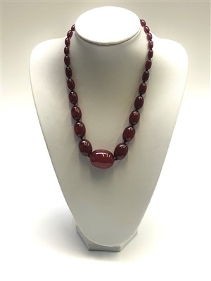 Lot 2583 - A 'cherry amber' necklace, the largest...
