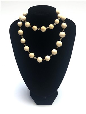 Lot 2594 - An ivory bead and gold link necklace.