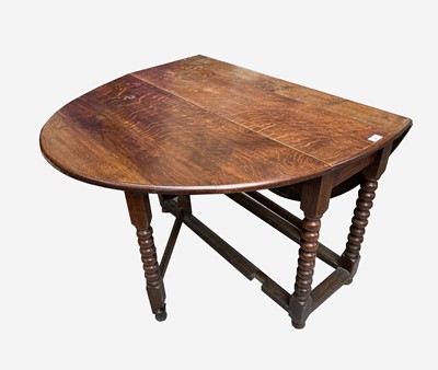 Lot 92 - An oak gateleg dining table, the oval top on...