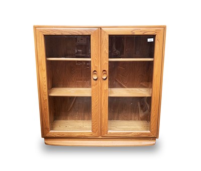 Lot 3065 - An Ercol light elm bookcase, with two glazed...