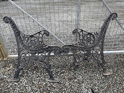 Lot 636 - A pair of black painted cast iron bench ends....