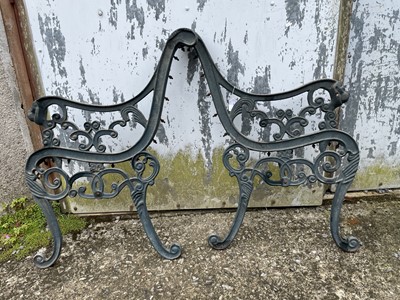 Lot 637 - A pair of green painted cast iron bench ends....