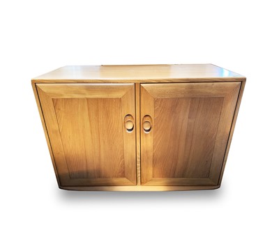 Lot 3070 - An Ercol light elm two door side cabinet, one...