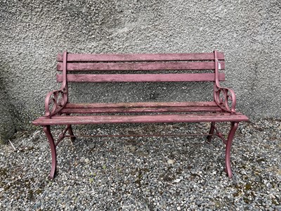 Lot 647 - A red painted garden bench, the metal ends...