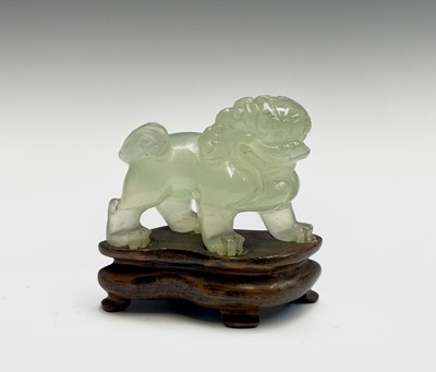 Lot 358 - A Chinese jade dog of fo, on a wooden stand,...