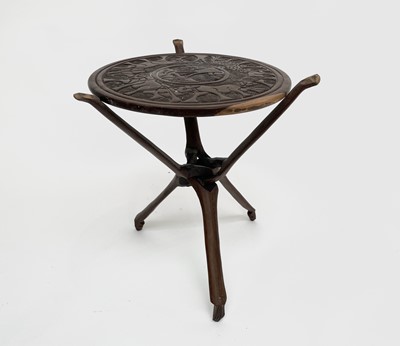 Lot 334 - An African carved hardwood table, raised on a...
