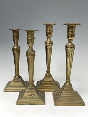 Lot 130 - Two pairs of 18th century brass candlesticks,...
