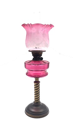Lot 1 - A brass and cranberry glass oil lamp, circa...