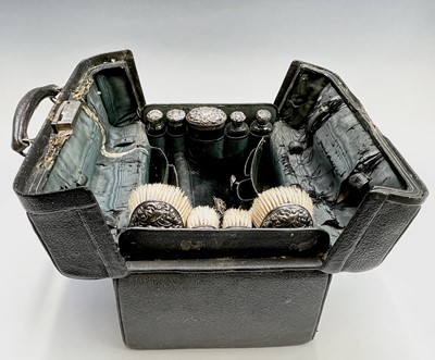 Lot 96 - An Edwardian black leather toilet case with...