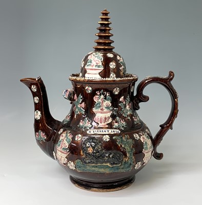 Lot 815 - A Measham treacle glazed barge ware teapot,...