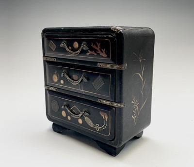 Lot 374 - A Japanese miniature black laquer chest of...