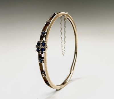 Lot 220 - A 9ct gold diamond and sapphire bangle 50x58mm...