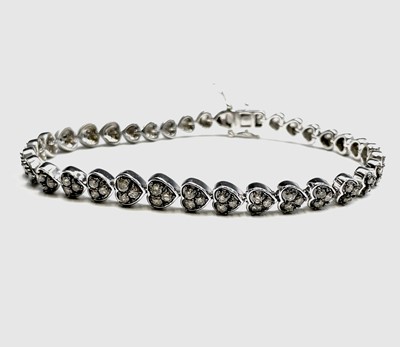 Lot 235 - A diamond line bracelet set in white metal...