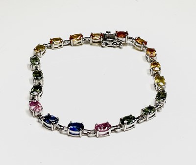 Lot 255 - Multi coloured sapphire bracelet set with blue,...