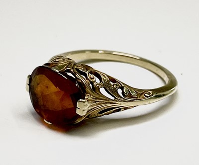 Lot 306 - An American gold ring set an orange brown...