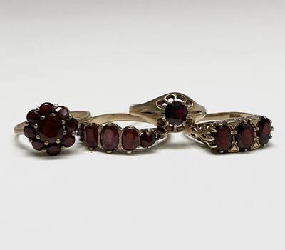Lot 407 - Four gold rings set with garnets Sizes range...