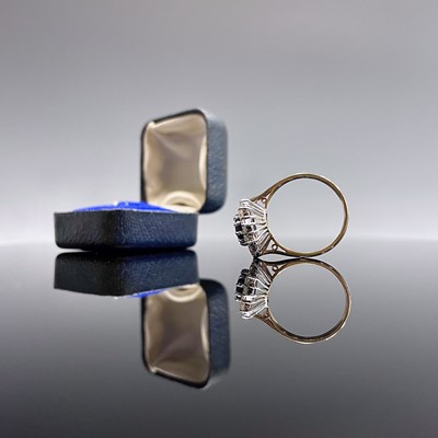 Lot 190 - An 18ct yellow gold ring set an oval sapphire...