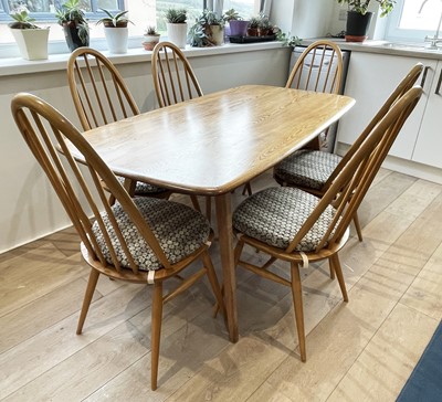 Lot 285 - An Ercol pale elm dining table with set of six...