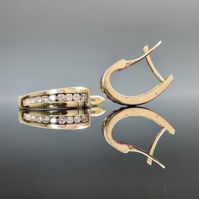 Lot 767 - A pair of 10k gold diamond channel set...