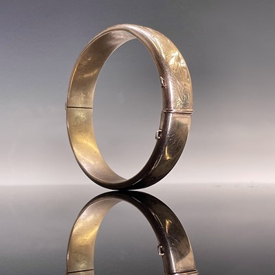 Lot 410 - A 9ct gold hinged hollow bangle with foliate...