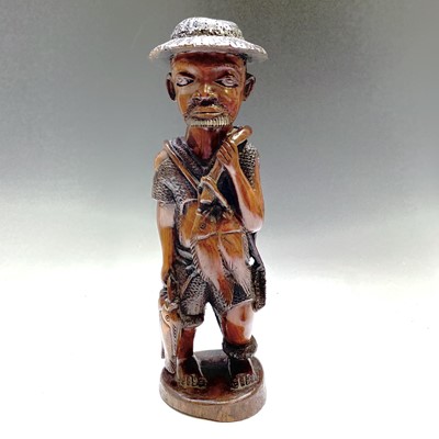 Lot 69 - An African hardwood figure of a fisherman,...